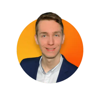 Eine Person mit kurzen Haaren, einem blauen Blazer und einem weißen Hemd lächelt. Der Hintergrund ist ein Farbverlauf aus Orangetönen innerhalb eines kreisförmigen Rahmens, ideal für ein modernes Webdesign oder eine ansprechende Homepage.
